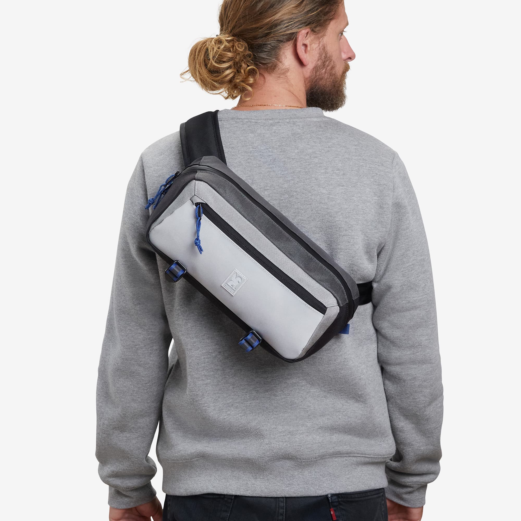 Mini Kadet Sling 5L in grey reflective worn by a man #color_fog