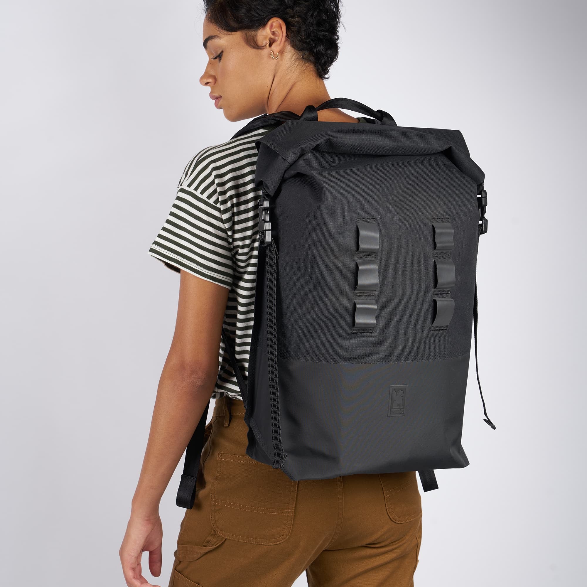 Waterproof 30L rolltop backpack in black worn by a woman #color_black