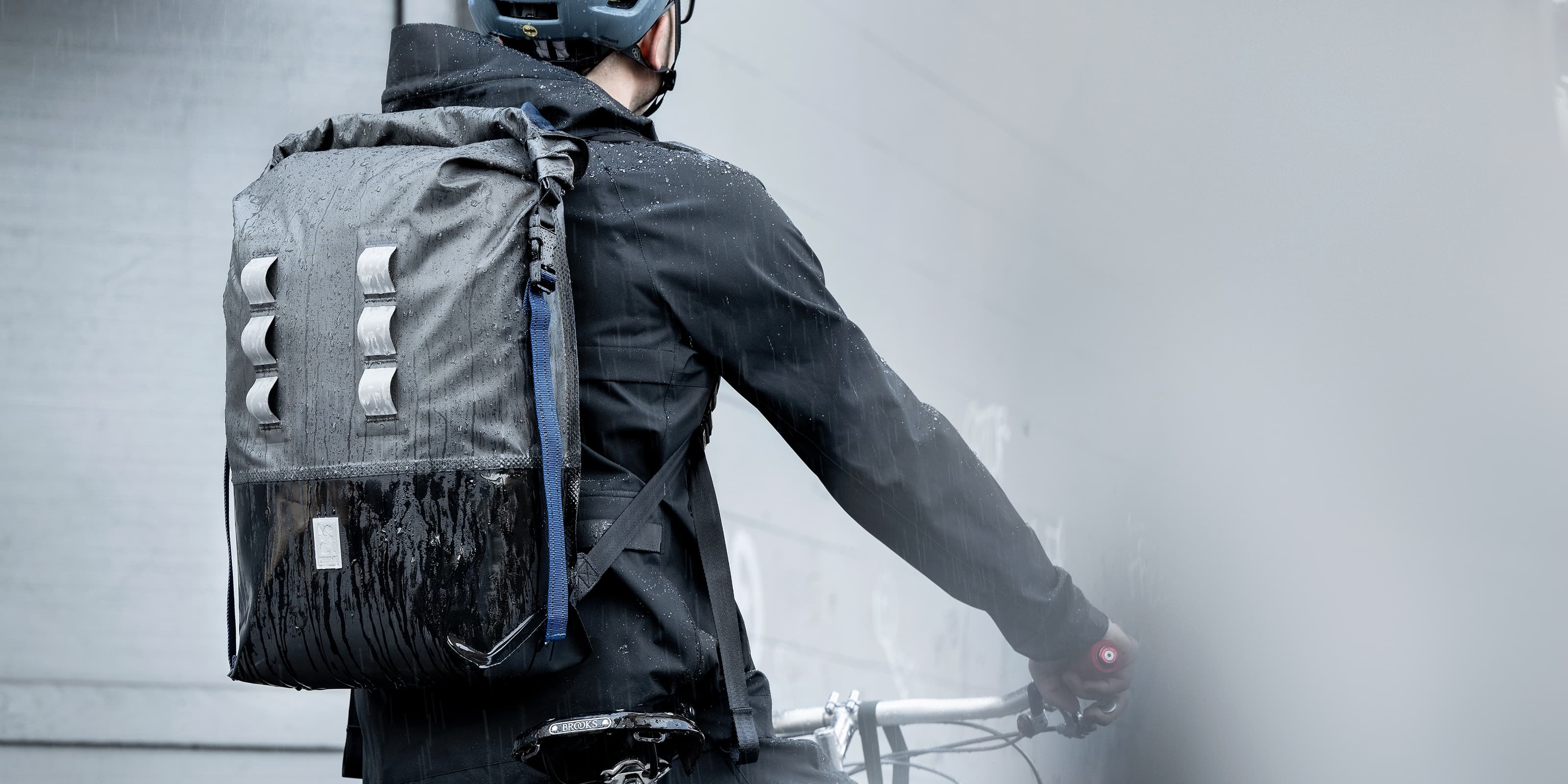 Urban Ex 30L Backpack worn by a guy on a bike in the rain desktop image size